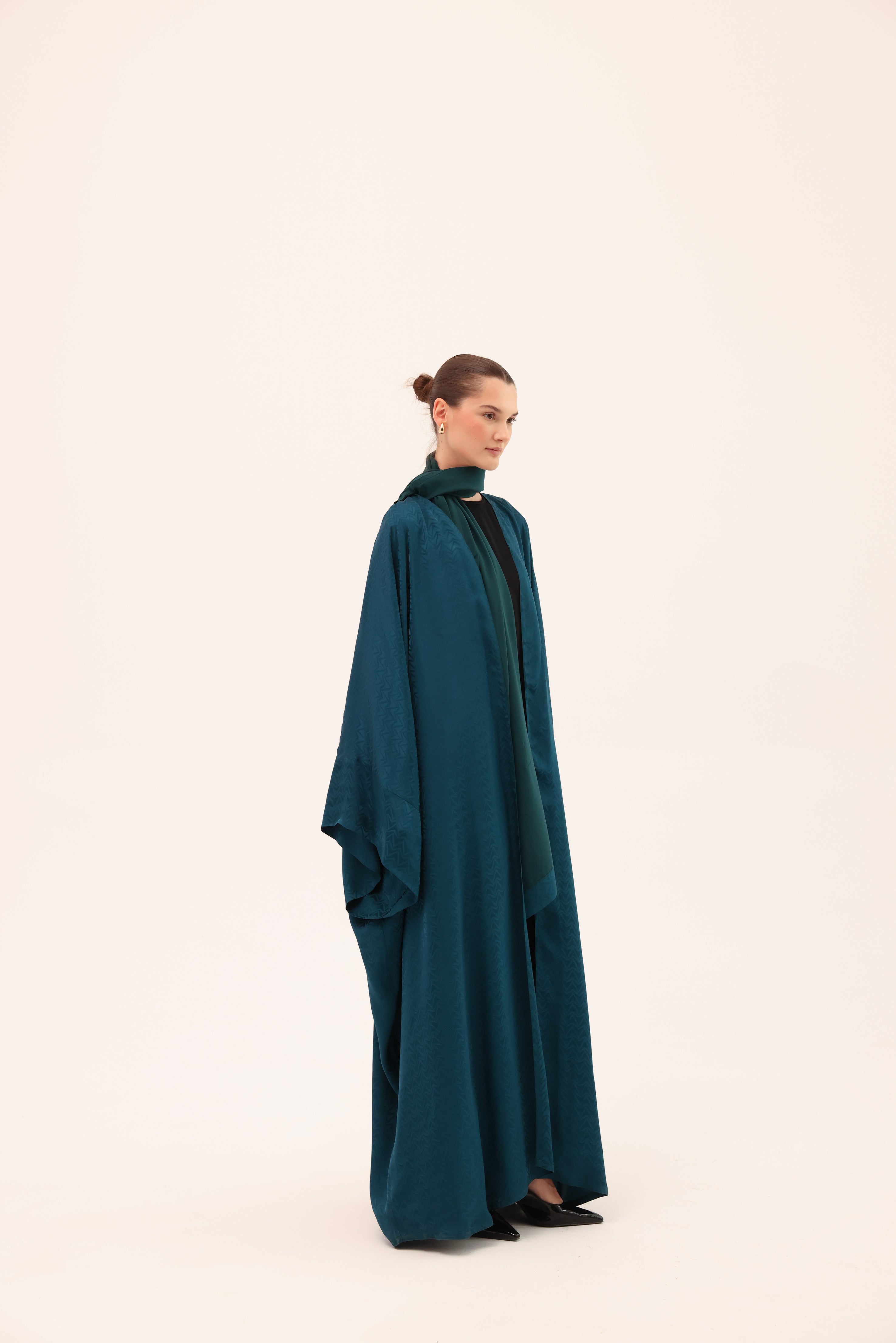 Model wearing the LUCE luxury turquoise silk abaya by Tre Sorelle, front view.