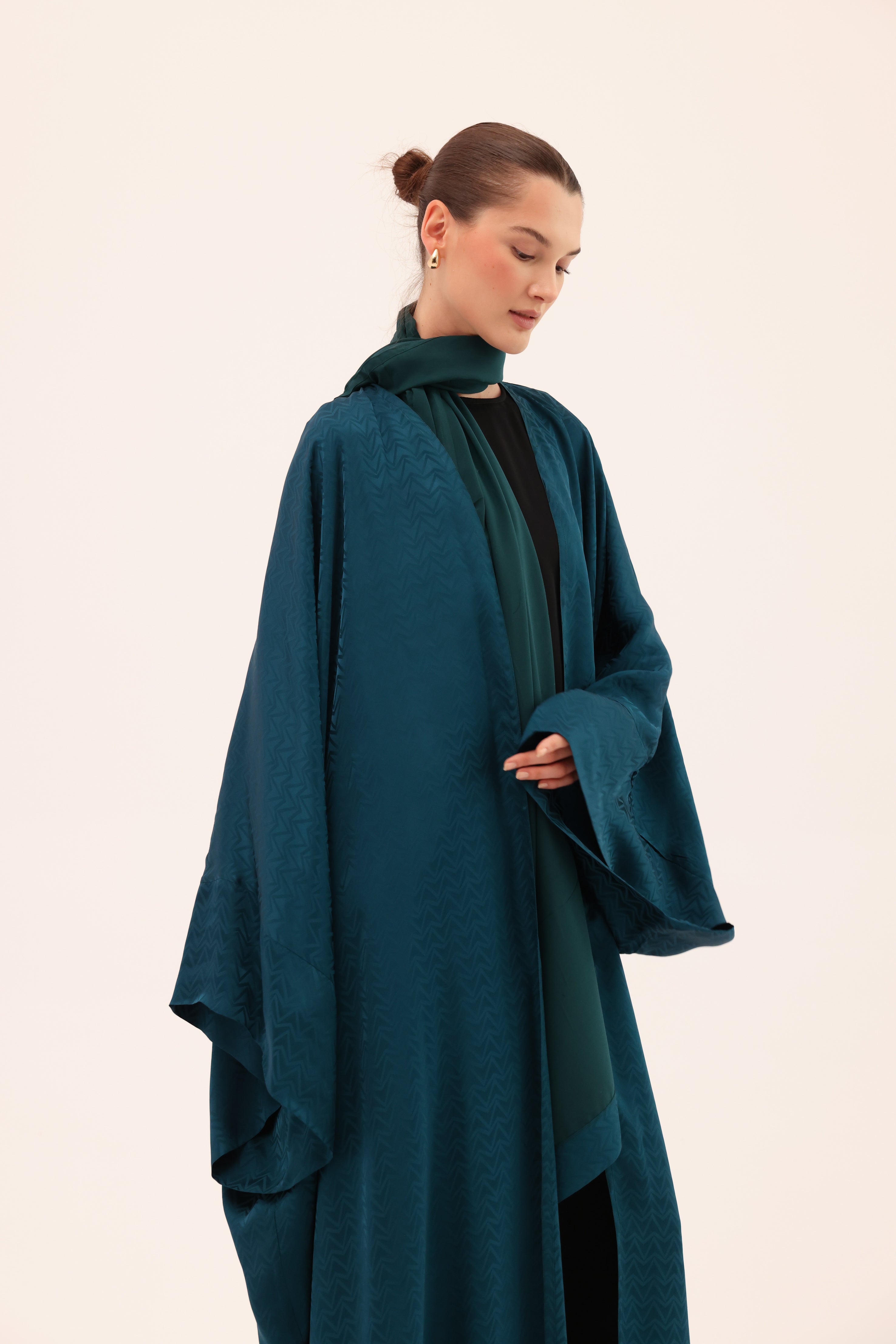 Close-up of Signature Sorelle Silk™ fabric on the LUCE luxury turquoise abaya by Tre Sorelle.