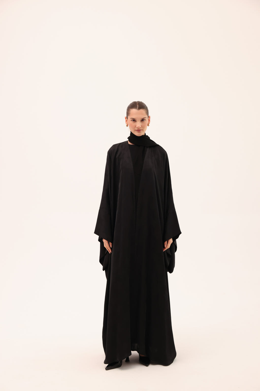 Model wearing the NOTTE luxury black silk abaya by Tre Sorelle, front view.
