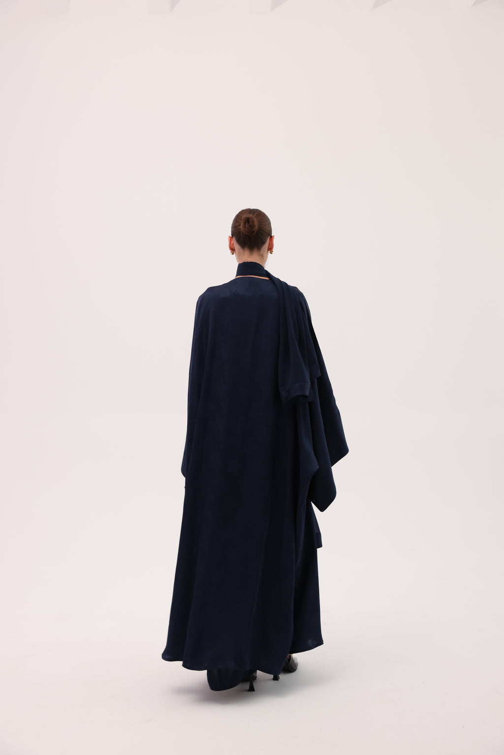 Model wearing the CIELO luxury navy blue silk abaya by Tre Sorelle, back view.